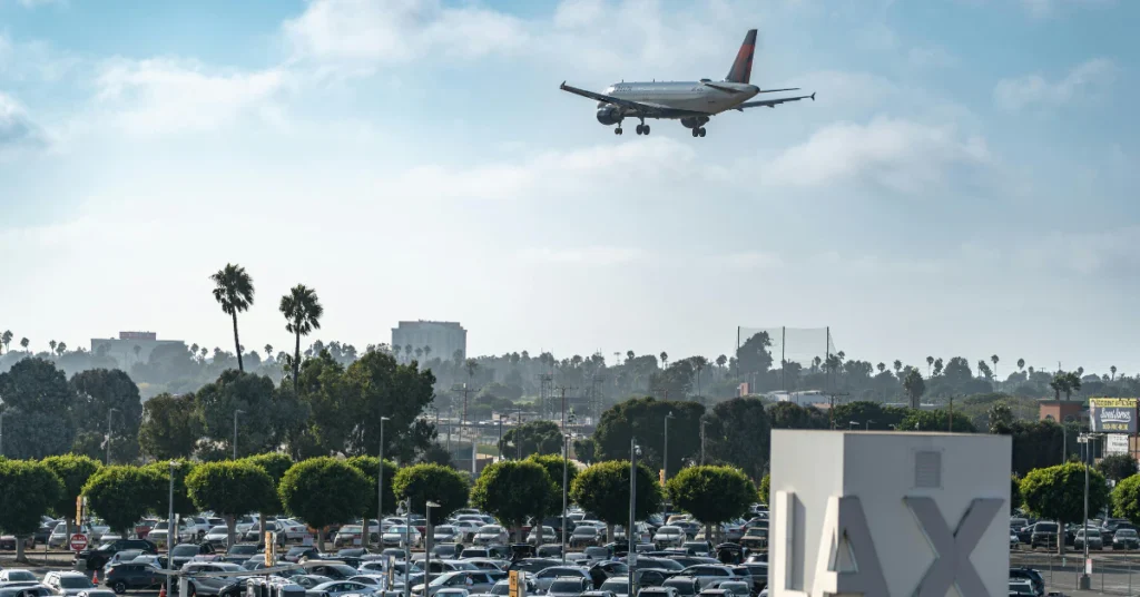 Airplane flying over a parking lot near LAX airport