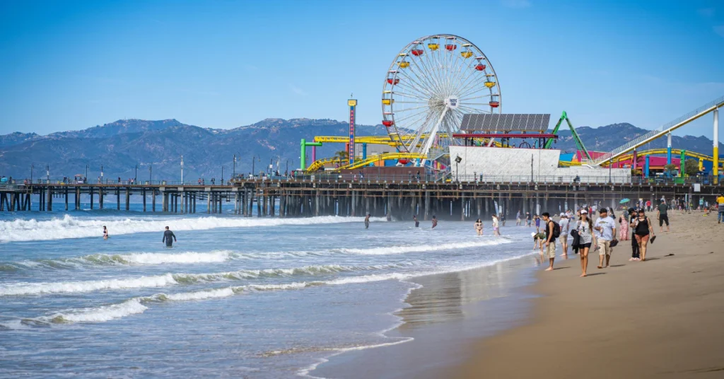 Santa Monica Pier with a Ferris wheel and beach in the foreground