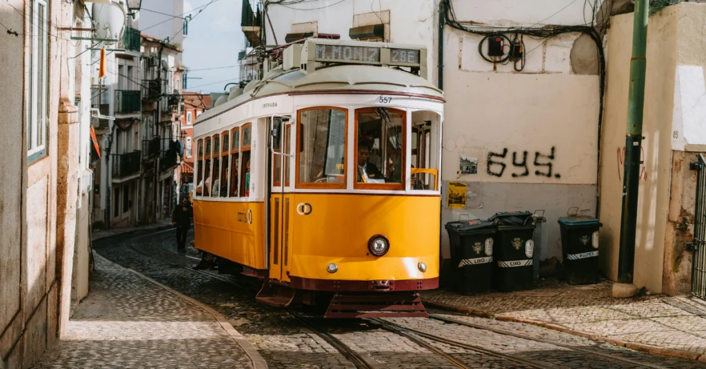 Yellow tram on narrow street in Alfama Lisbon