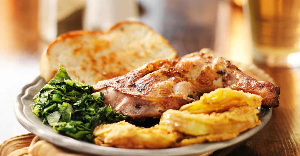 Southern roasted chicken with collard greens and fried green tomatoes, a classic Savannah, Georgia meal