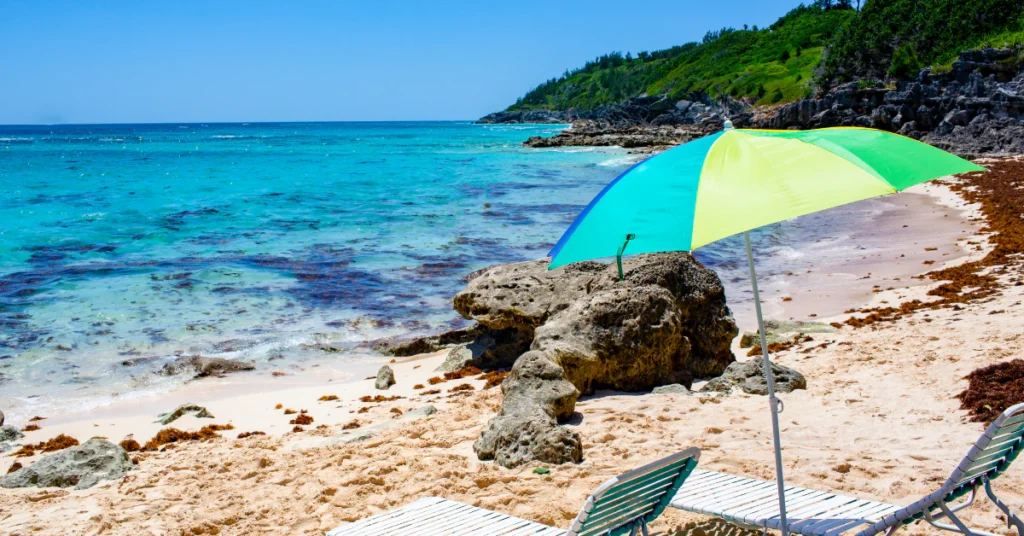 Bermuda weather by month, sunny beach with a colorful umbrella