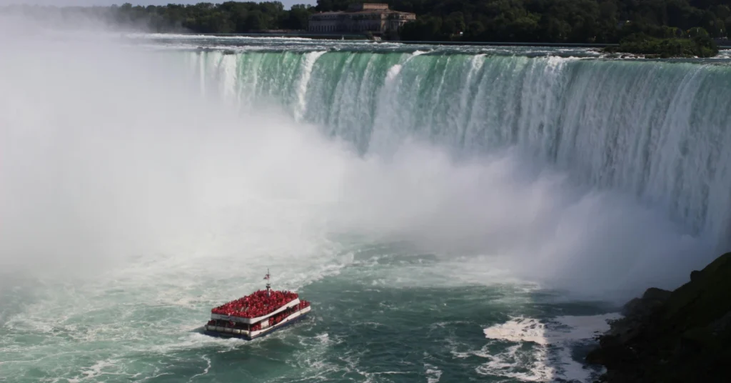 Red tour boat sailing into the mist at the base of Horseshoe Falls