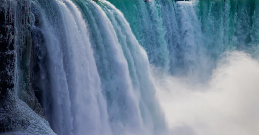 Close-up of Niagara Falls with water rushing over the edge and mist rising