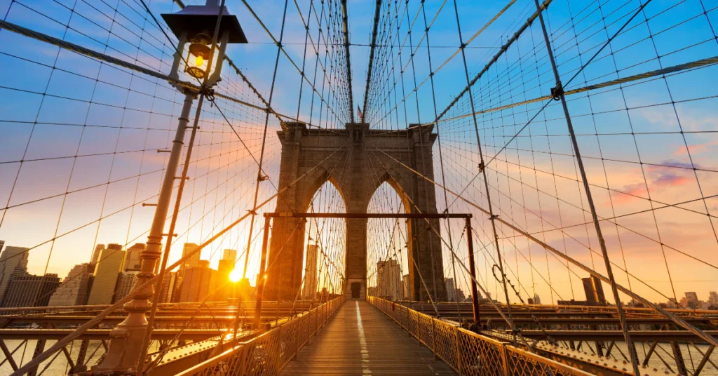 Brooklyn Bridge cables and walkway at sunset, one of the core NYC icons