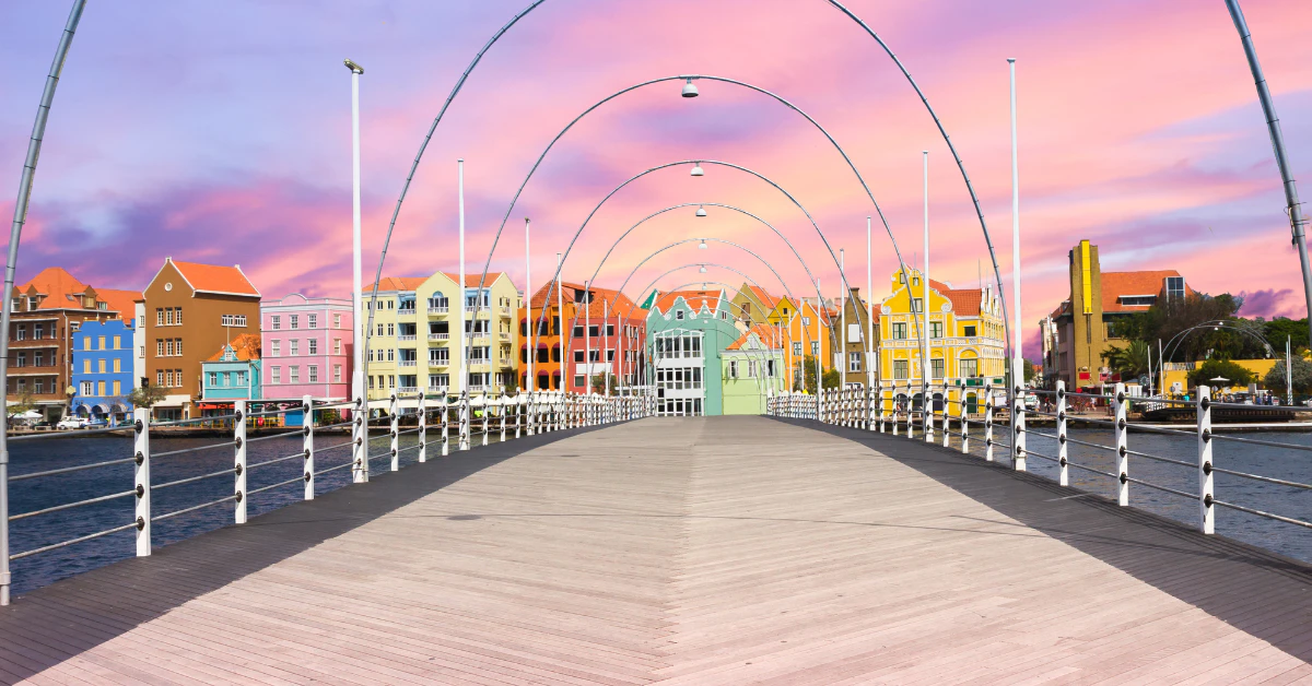Queen Emma Bridge at sunset with colorful buildings of Willemstad in Curaçao