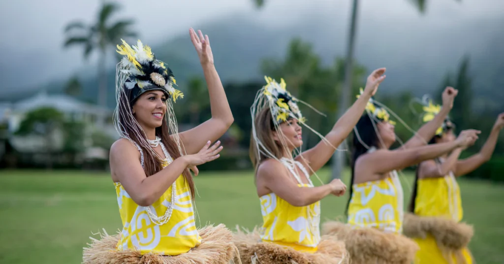 Hula dancers in yellow costumes performing outdoors at a Hawaiian cultural festival