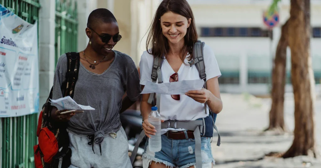 Group of young travelers walking together while looking at a map