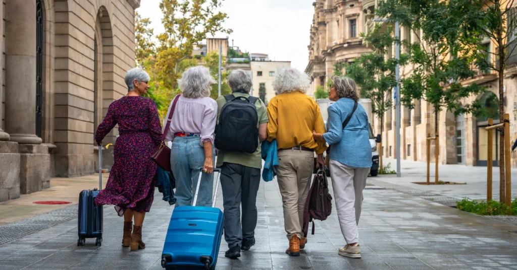Group of tourists walking with luggage along a city street
