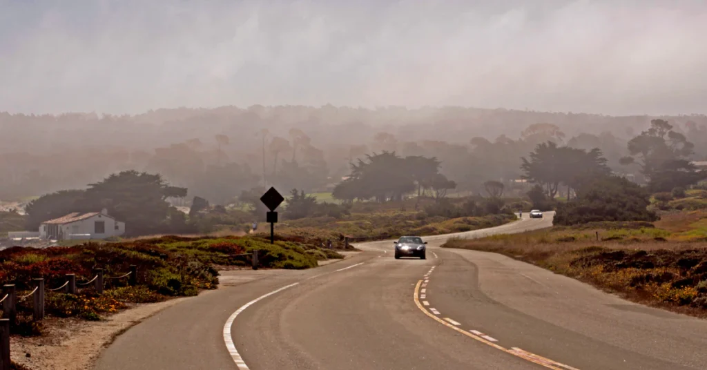 Winding coastal road with misty hills in the background