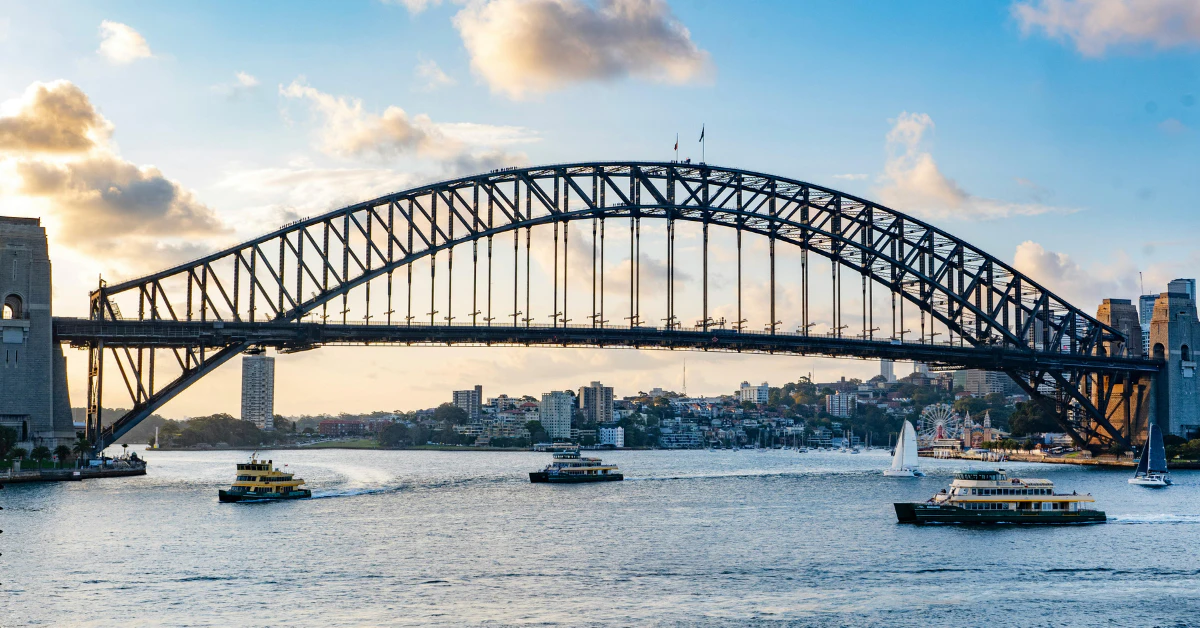 Sydney Harbour Bridge arching over the harbour with the city skyline in the background