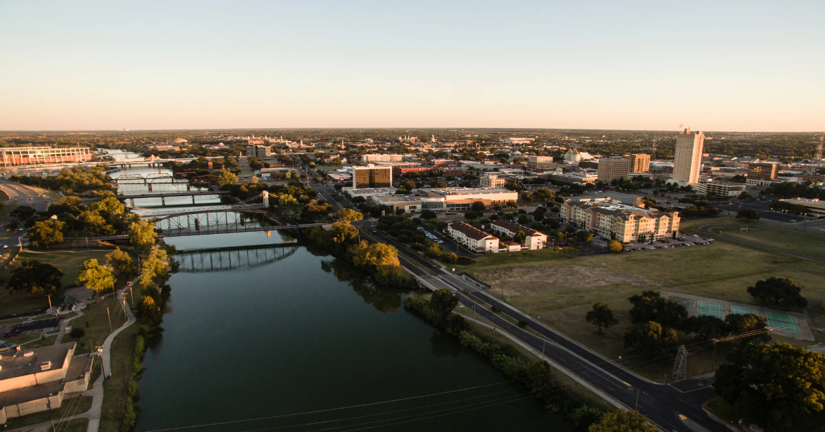 Aerial view of a river running through a city at sunset