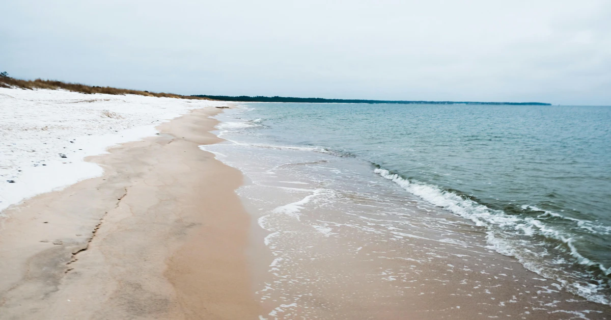 Empty sandy beach with gentle waves along the coast