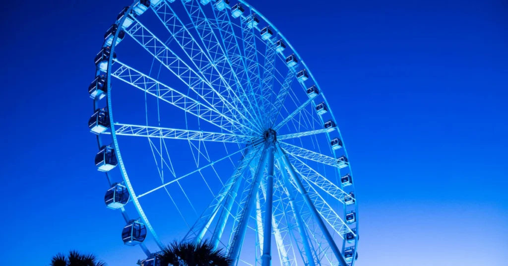 Large Ferris wheel lit against a deep blue sky
