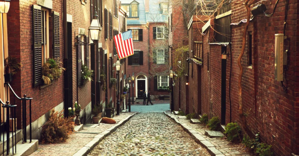 Cobblestone street lined with historic red brick townhouses in Beacon Hill